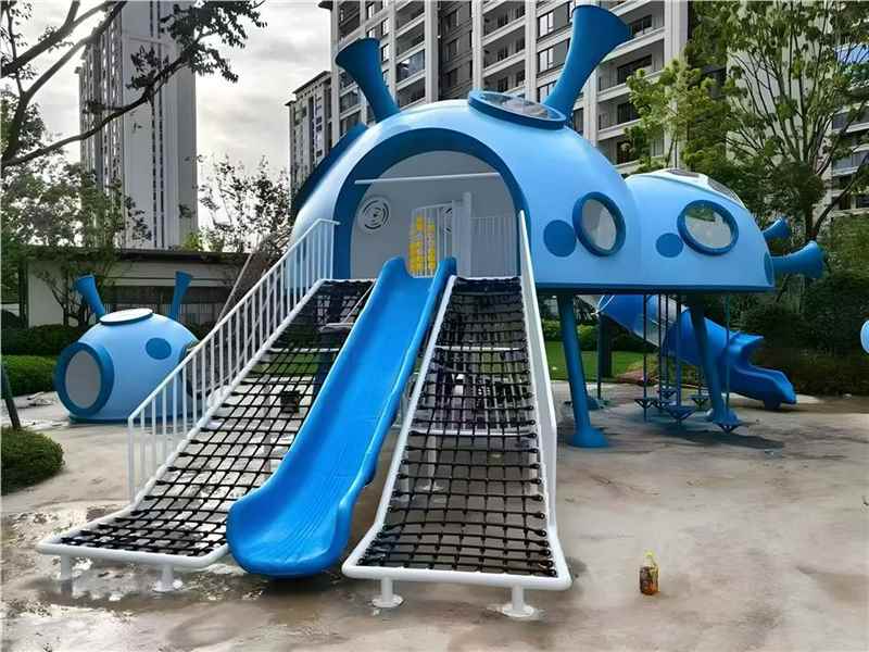 Outdoor playground project with blue slide and climbing net