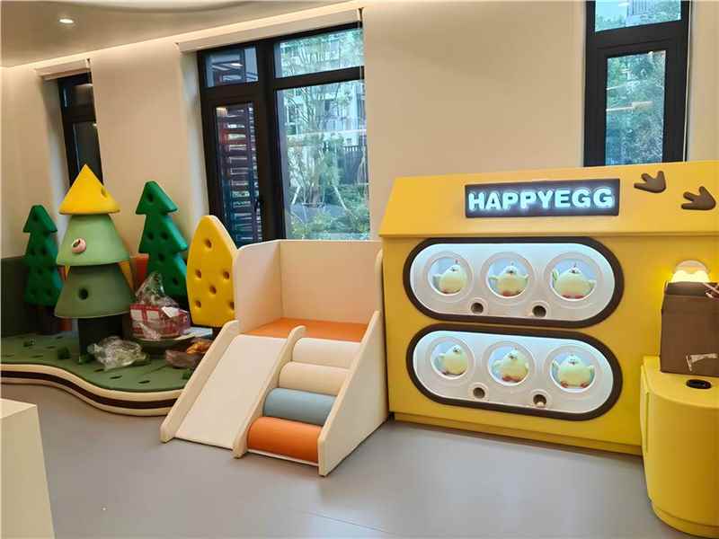 Kindergarten playroom with small slide and activity wall